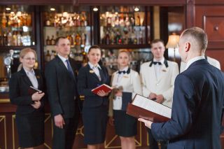 © Andrey - stock.adobe.com Foto: Hotelpersonal bei Meeting