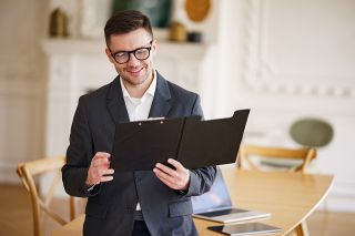 © muse studio - Adobe Stock.com Foto: Mann hält Dokumentenmappe