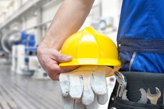 © industrieblick - Adobe Stock.com Foto: Gelber Arbeitshelm und Handschuhe