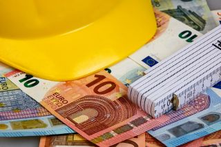 © Ideenkoch - stock.adobe.com Foto: Bauhelm, Zollstock und Geldscheine