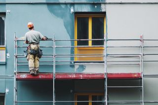 © vasyan_23 - stock.adobe.com Foto: Bauarbeiter auf Baugerüst